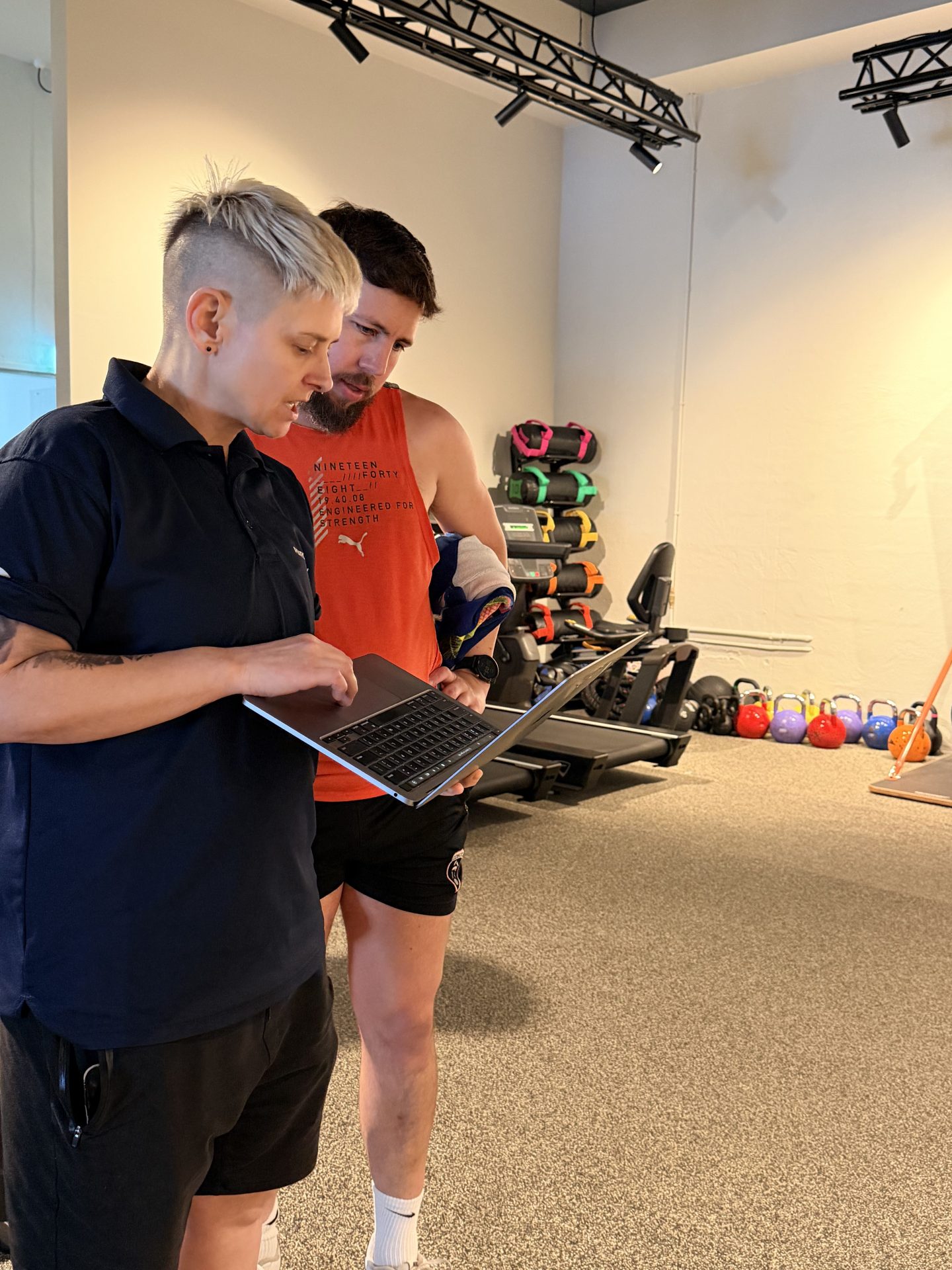 Exercise physiologist reviewing a program on a laptop with a client at PerforMotion